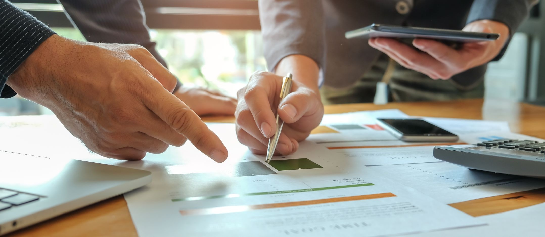 Profesionales analizando documentos y proyecciones financieras